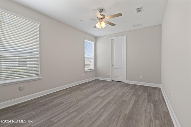 empty room with ceiling fan and light wood-type flooring