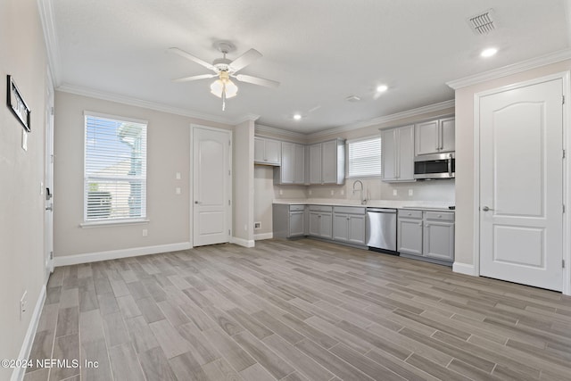 kitchen featuring gray cabinetry, light hardwood / wood-style flooring, ornamental molding, and appliances with stainless steel finishes