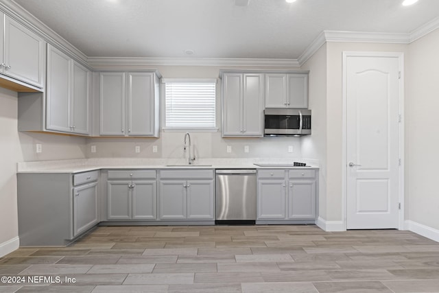 kitchen with gray cabinets, crown molding, sink, and appliances with stainless steel finishes