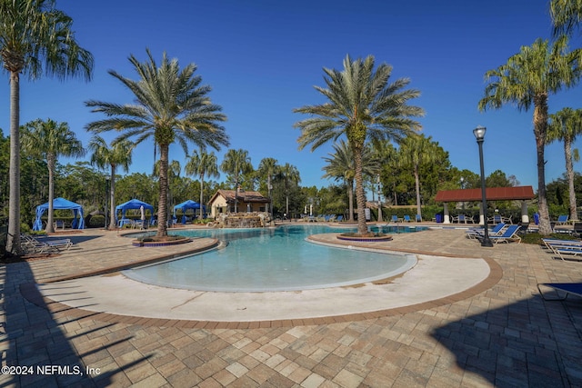 view of swimming pool with pool water feature and a patio area