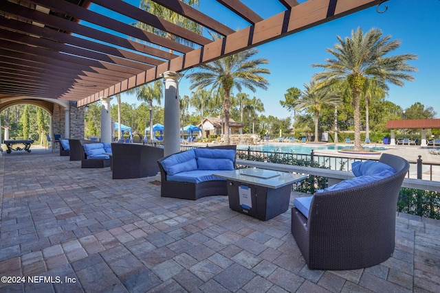 view of patio / terrace with an outdoor living space with a fire pit, a pergola, and a community pool