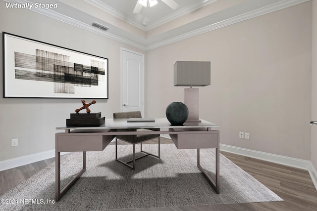 home office with a tray ceiling, crown molding, ceiling fan, and dark hardwood / wood-style floors