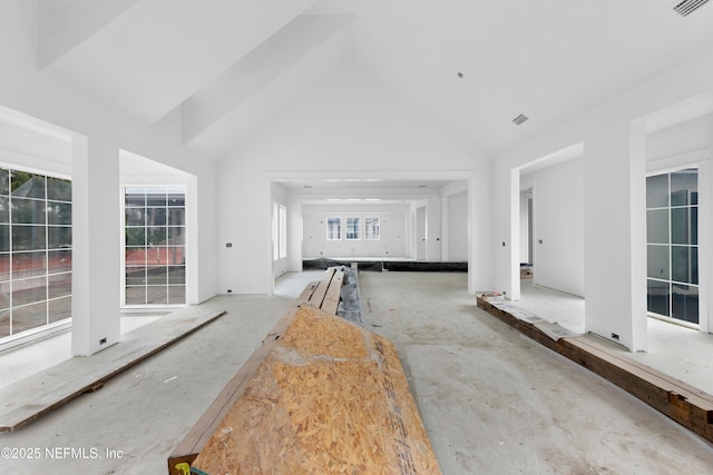 unfurnished living room with high vaulted ceiling