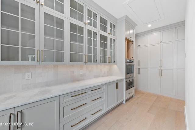 260 Autumn Tide Trl, Ponte Vedra, FL 32081 - kitchen featuring light wood-style flooring, decorative backsplash, glass insert cabinets, light stone counters, and recessed lighting