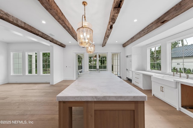260 Autumn Tide Trl, Ponte Vedra, FL 32081 - kitchen with a chandelier, beam ceiling, light wood-style floors, white cabinets, and hanging light fixtures