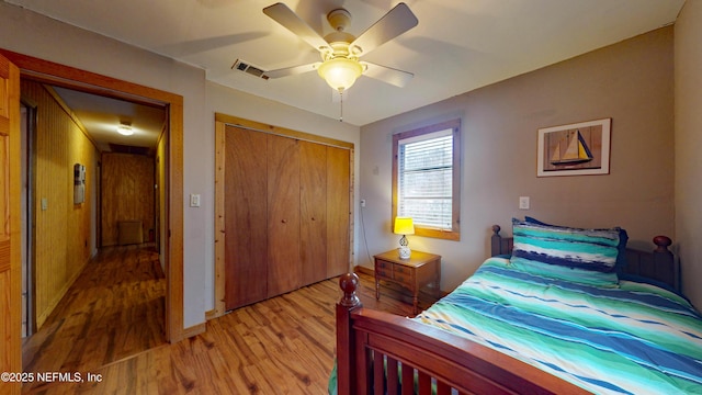 bedroom featuring hardwood / wood-style flooring, ceiling fan, and a closet