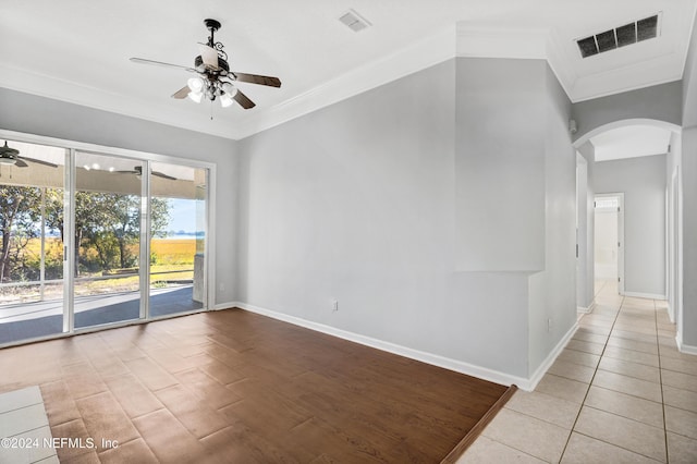 tiled spare room with ceiling fan and ornamental molding