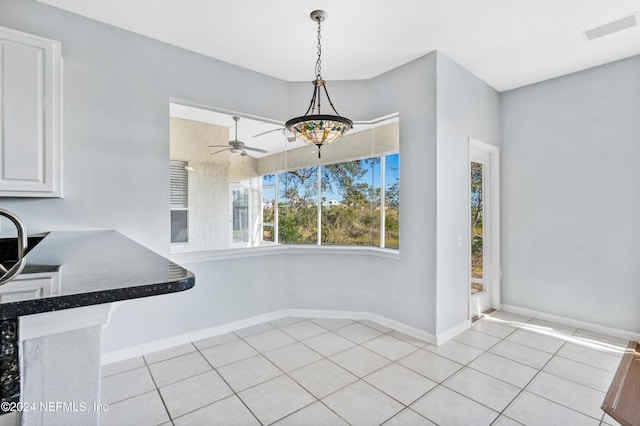 unfurnished dining area with ceiling fan and light tile patterned flooring