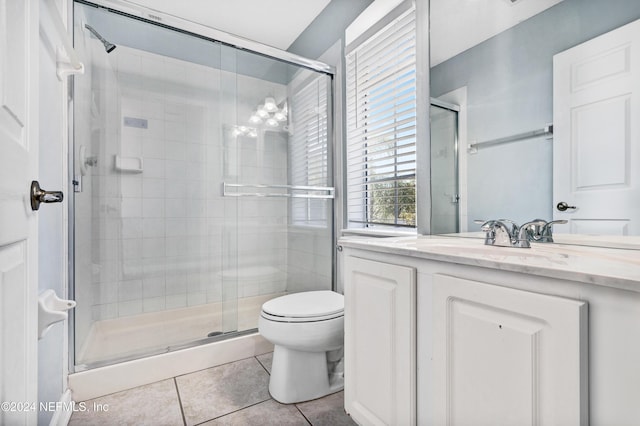 bathroom with tile patterned floors, vanity, toilet, and an enclosed shower