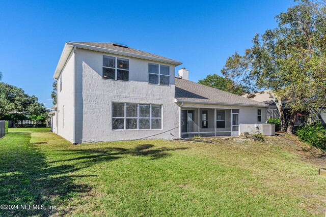 back of property featuring a sunroom, central AC unit, and a yard