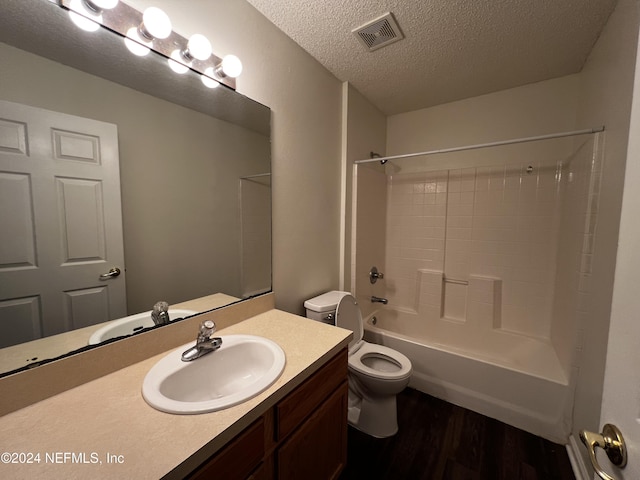 full bathroom with vanity, bathtub / shower combination, hardwood / wood-style flooring, toilet, and a textured ceiling