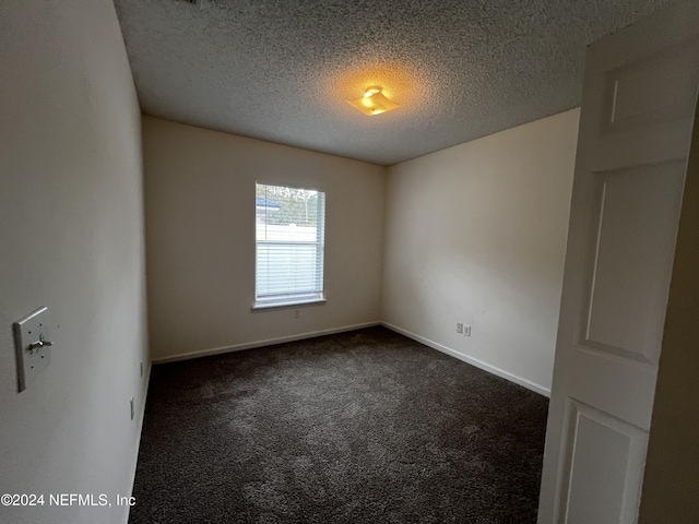 carpeted spare room with a textured ceiling