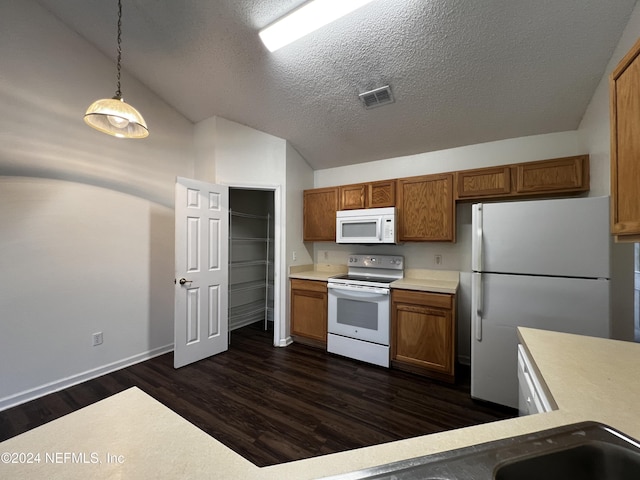 kitchen featuring white appliances, dark wood-type flooring, lofted ceiling, a textured ceiling, and decorative light fixtures