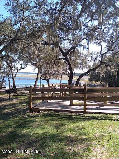 surrounding community with a lawn and a water view