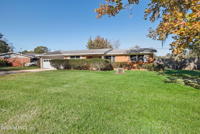 single story home featuring a garage and a front lawn