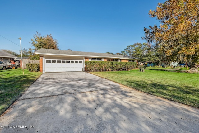 ranch-style house featuring a garage and a front lawn