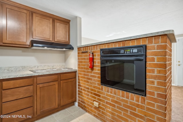 kitchen featuring light tile patterned floors, black oven, and electric stovetop