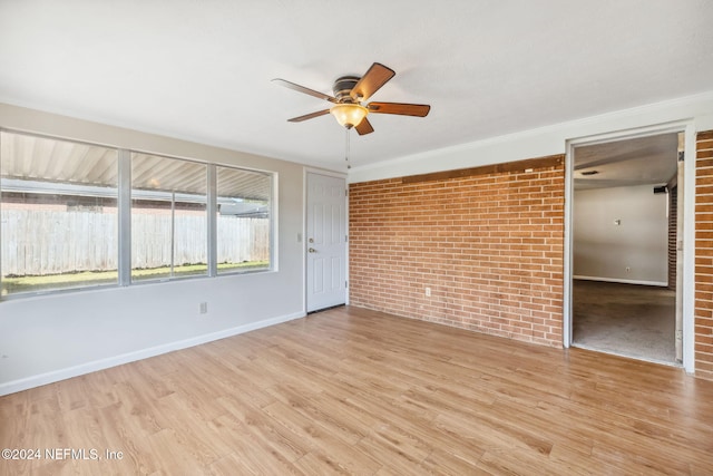 unfurnished bedroom featuring ceiling fan, brick wall, and light hardwood / wood-style flooring