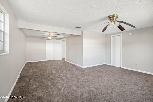 spare room with dark colored carpet, a textured ceiling, and ceiling fan