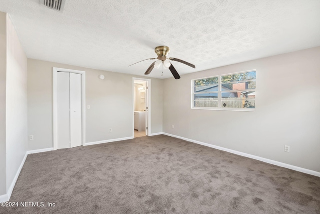 empty room featuring ceiling fan, carpet floors, and a textured ceiling