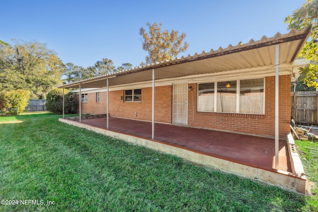 rear view of house featuring a patio area and a lawn