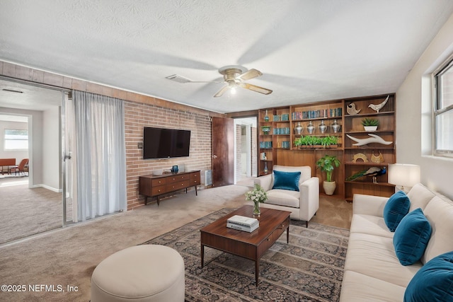 carpeted living room with ceiling fan and a textured ceiling