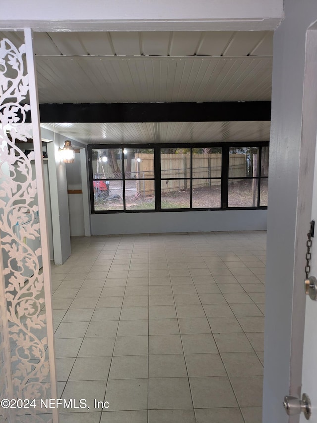 spare room with beamed ceiling, tile patterned floors, and wood ceiling