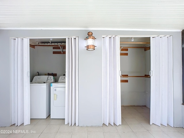 laundry area with independent washer and dryer and light tile patterned floors