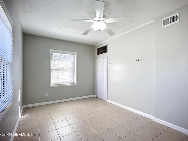 tiled spare room featuring ceiling fan and a textured ceiling