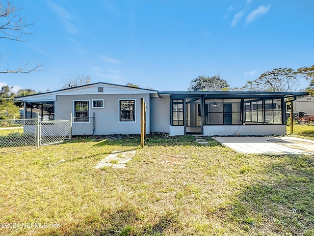 view of front of house with a front lawn and a sunroom