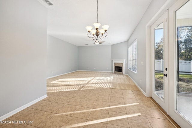 interior space with light tile patterned flooring, a wealth of natural light, and an inviting chandelier