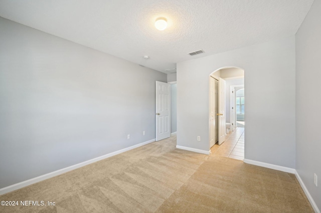 carpeted spare room with a textured ceiling