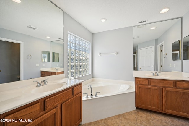 bathroom with tile patterned floors, a bathtub, and vanity