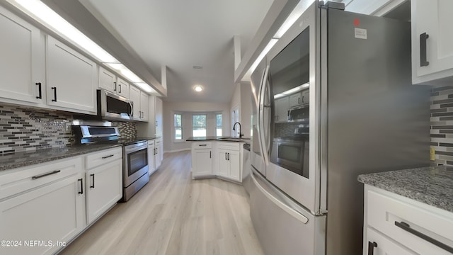 kitchen with tasteful backsplash, white cabinetry, stainless steel appliances, and sink