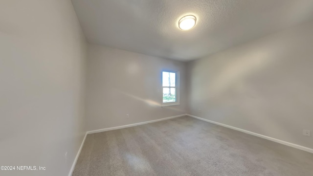 unfurnished room featuring carpet floors and a textured ceiling