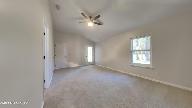 empty room with lofted ceiling, light colored carpet, and ceiling fan