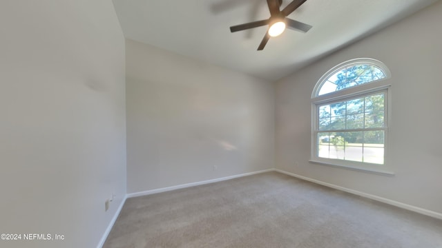 spare room with vaulted ceiling, light carpet, and ceiling fan