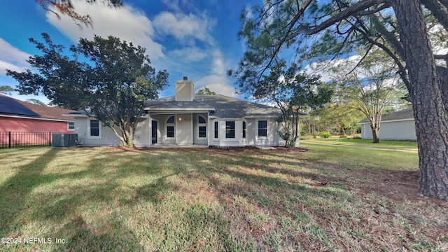 view of front facade featuring a front yard and central air condition unit