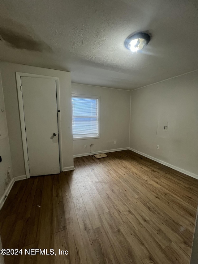 spare room with wood-type flooring and a textured ceiling