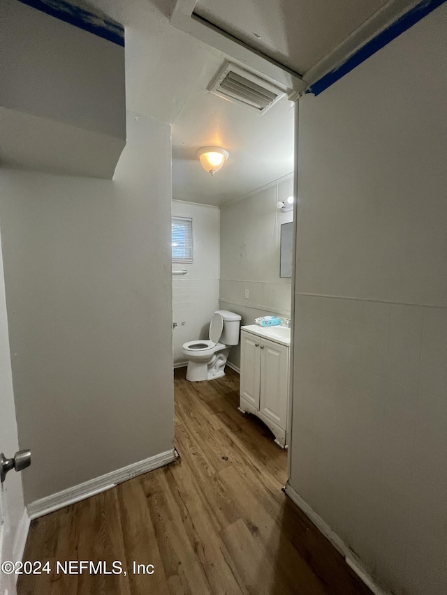 bathroom featuring toilet, vanity, and hardwood / wood-style flooring