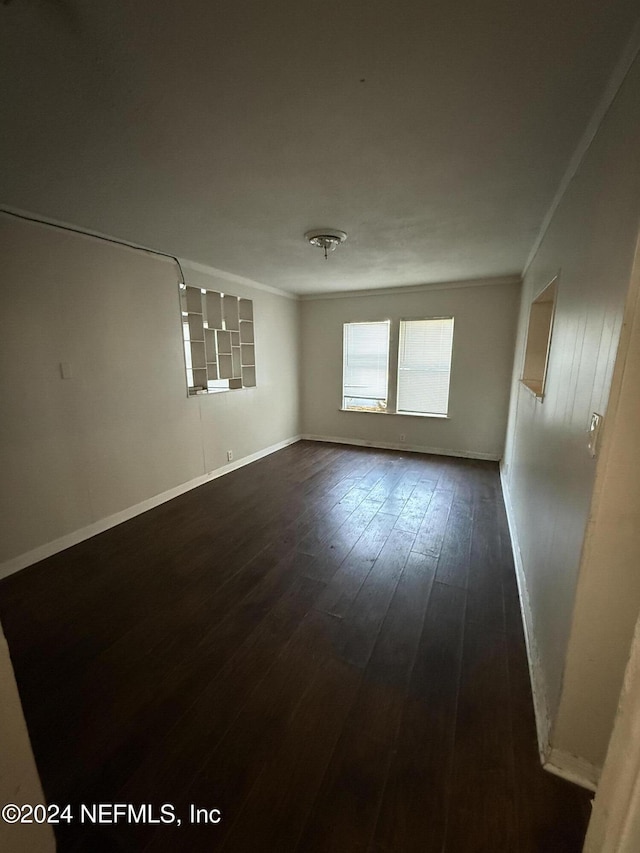 unfurnished room featuring dark hardwood / wood-style flooring and ornamental molding