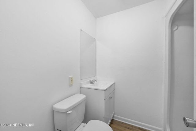 bathroom featuring toilet, vanity, and hardwood / wood-style flooring