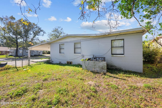 view of property exterior featuring a lawn and a carport