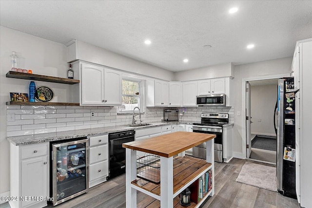 kitchen featuring stainless steel appliances, wine cooler, and white cabinetry