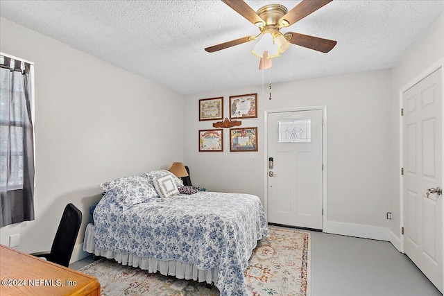 bedroom featuring concrete flooring, a textured ceiling, and ceiling fan