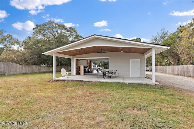 back of property with a lawn, ceiling fan, and a patio