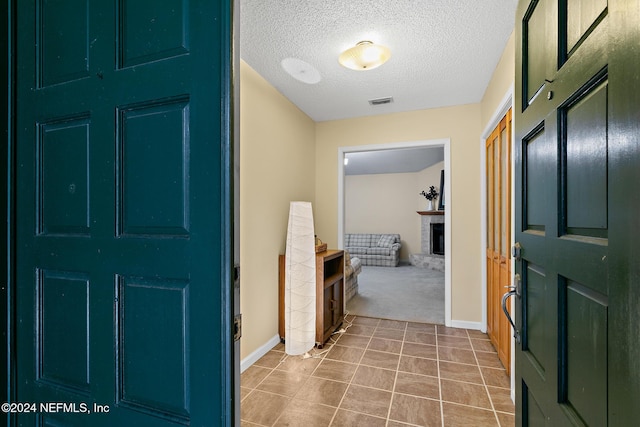 entryway featuring carpet flooring and a textured ceiling