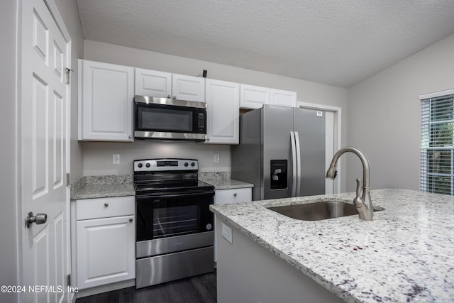 kitchen featuring white cabinets, light stone counters, sink, and appliances with stainless steel finishes