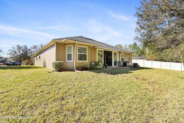 rear view of property with a lawn