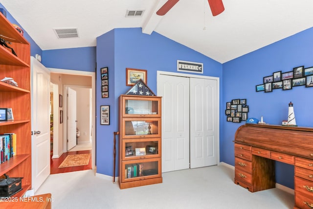 carpeted office space featuring ceiling fan and vaulted ceiling with beams